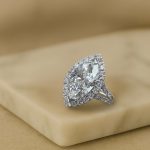 Marquise diamond engagement ring in white gold on beige background